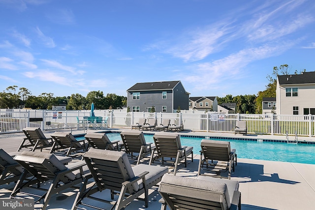 community pool featuring fence and a patio area