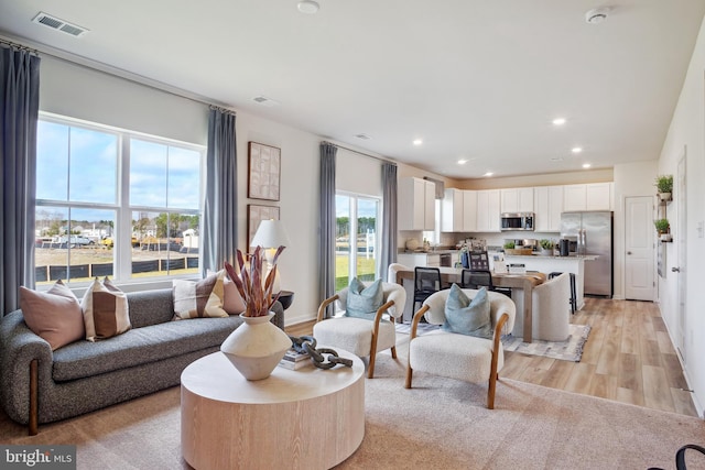 living area featuring visible vents, recessed lighting, and light wood-type flooring