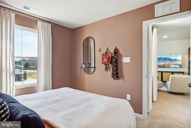 bedroom featuring light colored carpet, baseboards, and visible vents