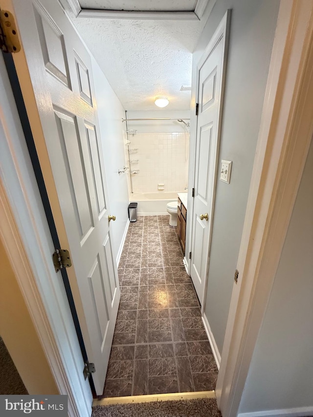 hall featuring baseboards and a textured ceiling