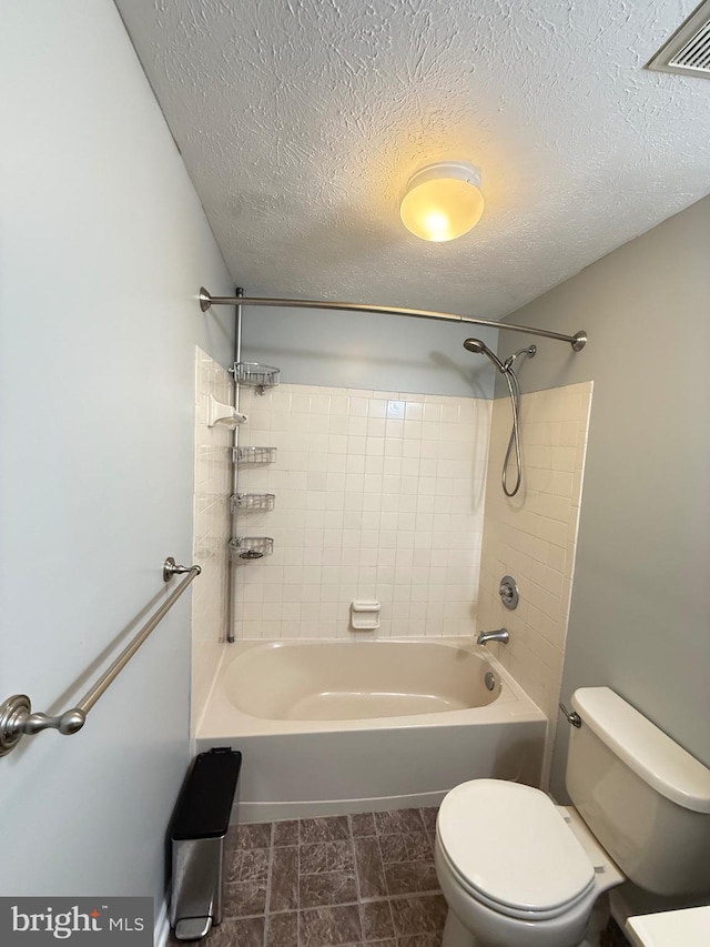 bathroom with toilet, a textured ceiling, and bathtub / shower combination