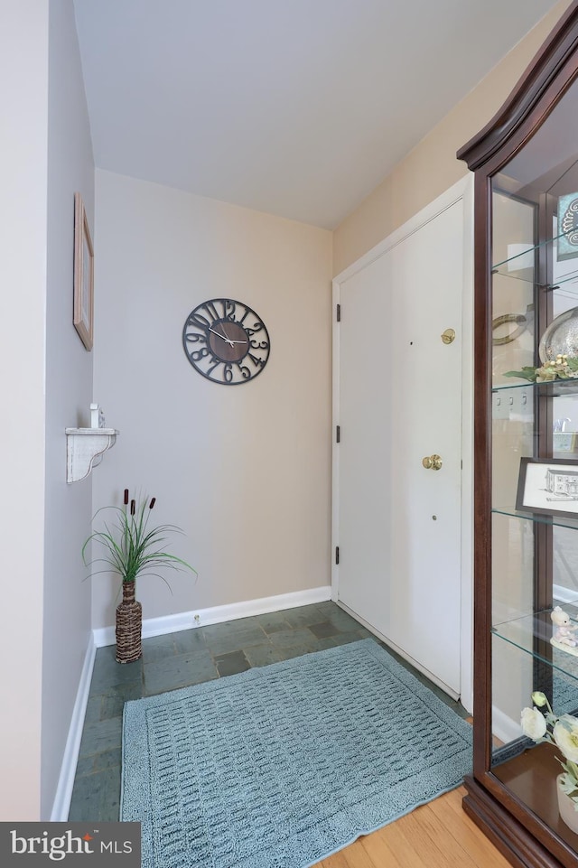 foyer entrance featuring baseboards