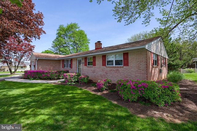ranch-style home featuring brick siding, a front lawn, and a chimney