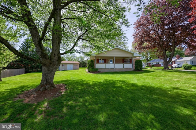 exterior space with a yard, brick siding, fence, and covered porch