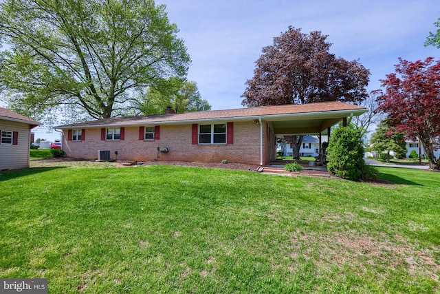 rear view of property with brick siding, central air condition unit, a yard, and a chimney