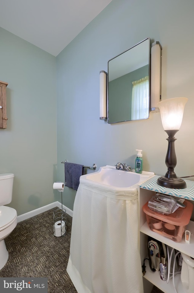 half bath with toilet and baseboards