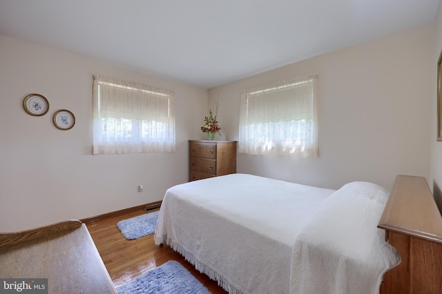 bedroom featuring baseboards and wood finished floors
