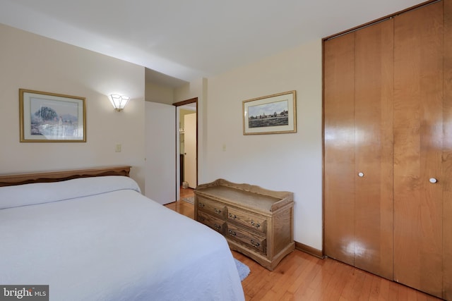 bedroom with light wood-style floors and a closet