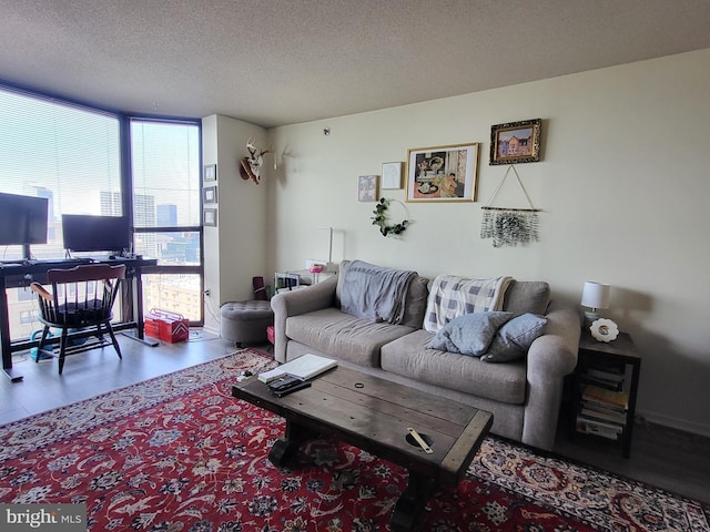 living room with a textured ceiling, floor to ceiling windows, and wood finished floors