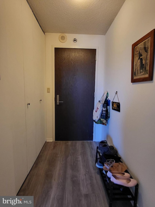 entryway with a textured ceiling and wood finished floors