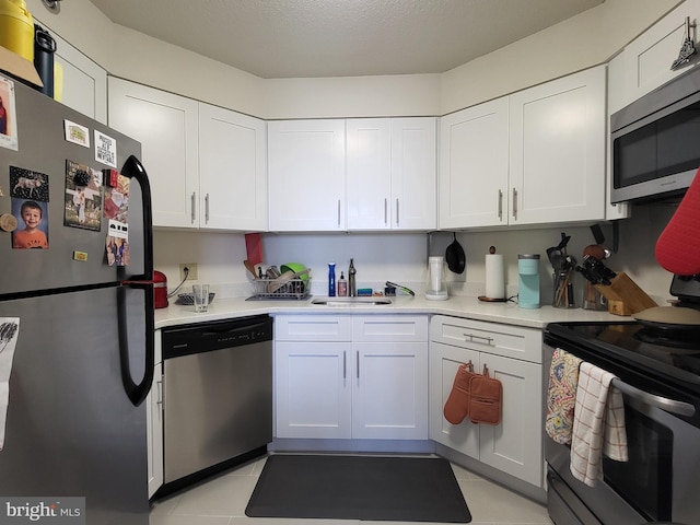 kitchen featuring a sink, light countertops, stainless steel appliances, and white cabinetry