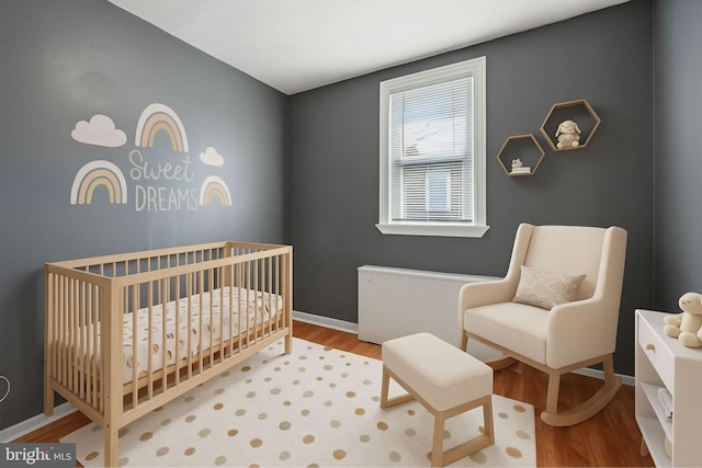 2062 E Stella St, Philadelphia, PA 19134 - bedroom featuring a crib, baseboards, and wood finished floors