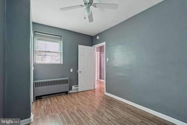 2062 E Stella St, Philadelphia, PA 19134 - empty room with ceiling fan, baseboard heating, radiator heating unit, baseboards, and wood finished floors