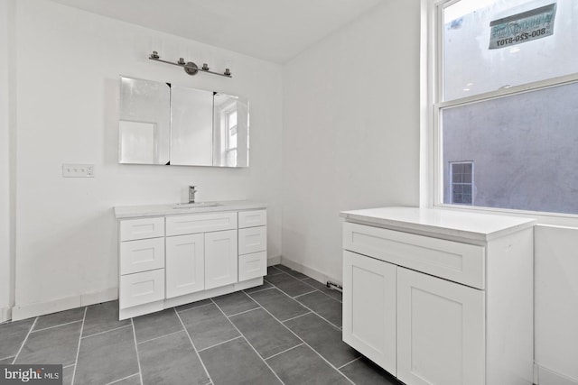 full bathroom with vanity, baseboards, and tile patterned floors
