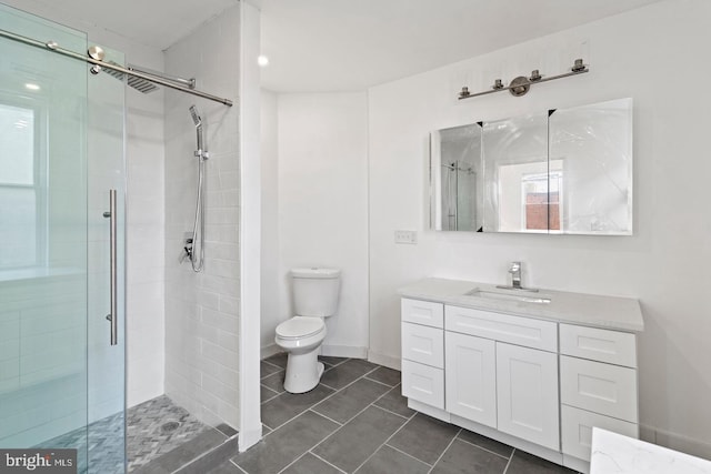 full bath featuring tile patterned flooring, vanity, toilet, and a shower stall