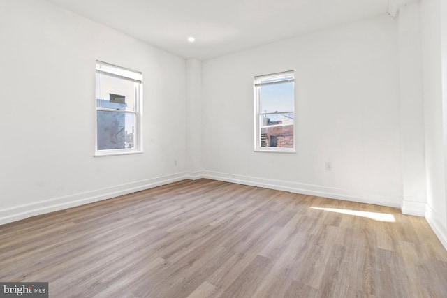 empty room with baseboards and light wood-style floors