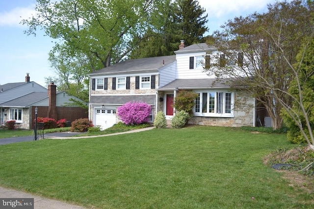 view of front of property with a garage, a front lawn, driveway, and stone siding