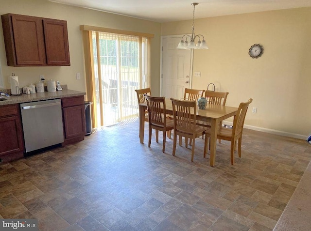 dining room featuring baseboards, a notable chandelier, and stone finish floor
