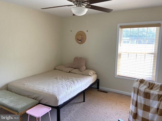 carpeted bedroom featuring baseboards, ceiling fan, and visible vents