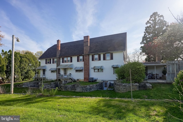 104 N Custer Ave, New Holland, PA 17557 - rear view of house with a lawn, central AC, and a chimney