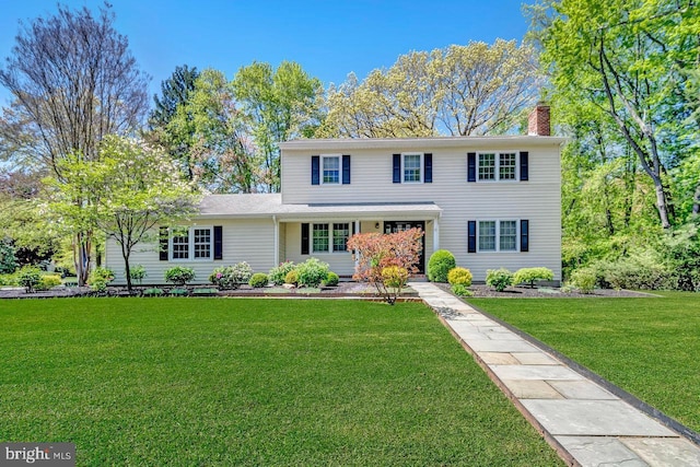 view of front of property with a chimney and a front yard