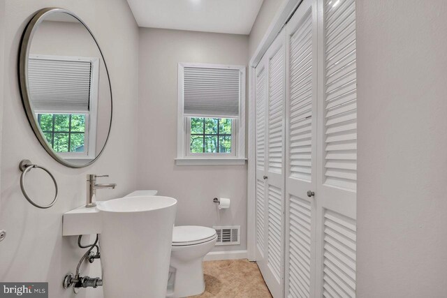 bathroom featuring visible vents, baseboards, a closet, and toilet