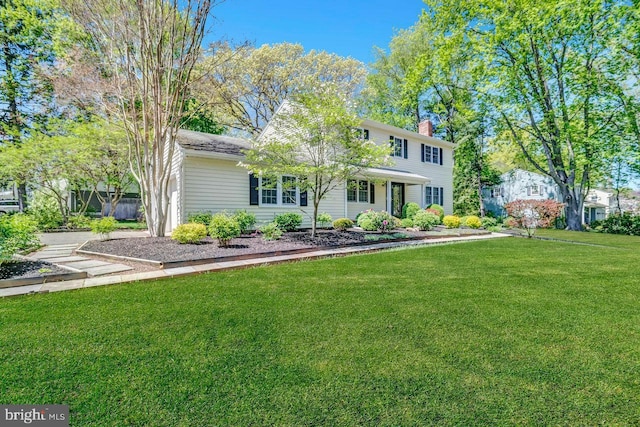 view of front of house with a front lawn and a chimney