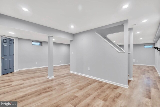 basement featuring recessed lighting, baseboards, and light wood-type flooring