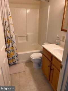full bath featuring vanity, tile patterned flooring, shower / bath combo, and toilet