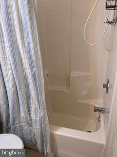 bathroom with toilet and shower / bath combo
