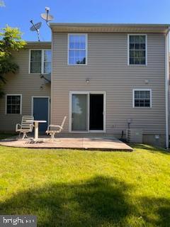 rear view of house with a patio and a yard