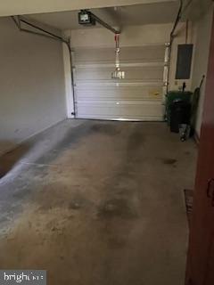 garage with a garage door opener and electric panel
