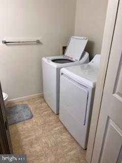 laundry area featuring baseboards, laundry area, and washer and clothes dryer