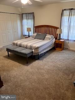 bedroom featuring a closet, ceiling fan, and carpet flooring