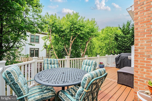 wooden deck with outdoor dining space and area for grilling