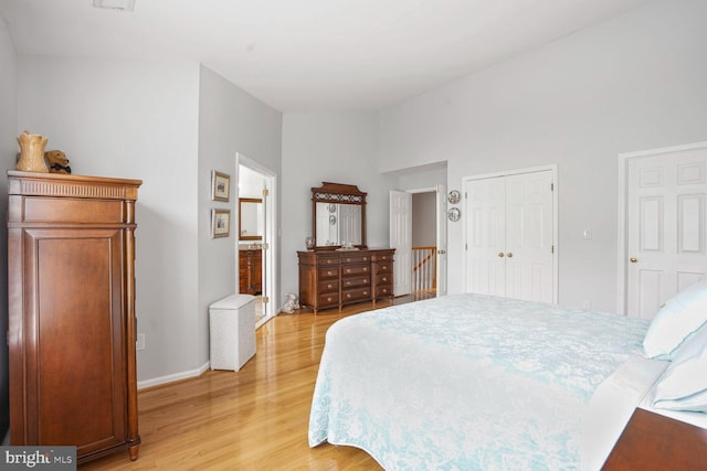 bedroom featuring light wood-style flooring, baseboards, and a closet