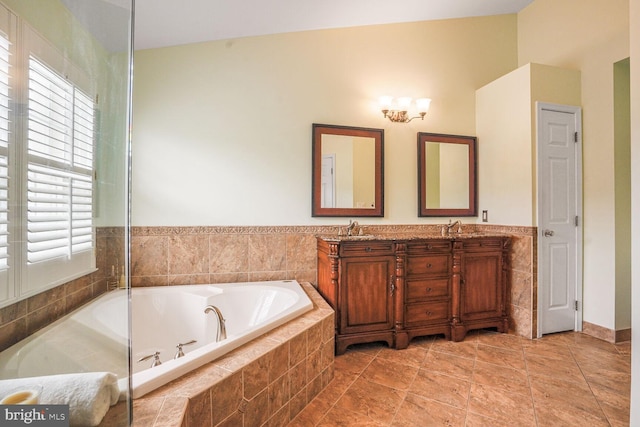 full bath featuring a sink, double vanity, a wealth of natural light, and a garden tub