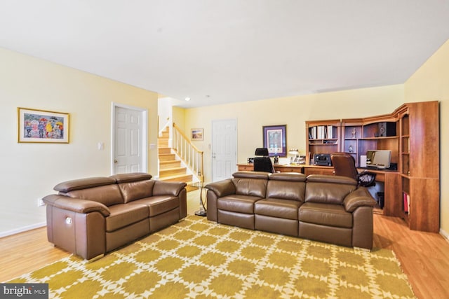 living room with stairs, baseboards, and wood finished floors