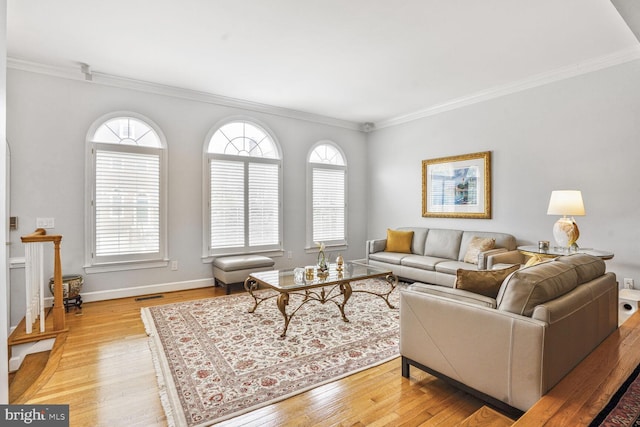 living room with crown molding, light wood finished floors, and visible vents