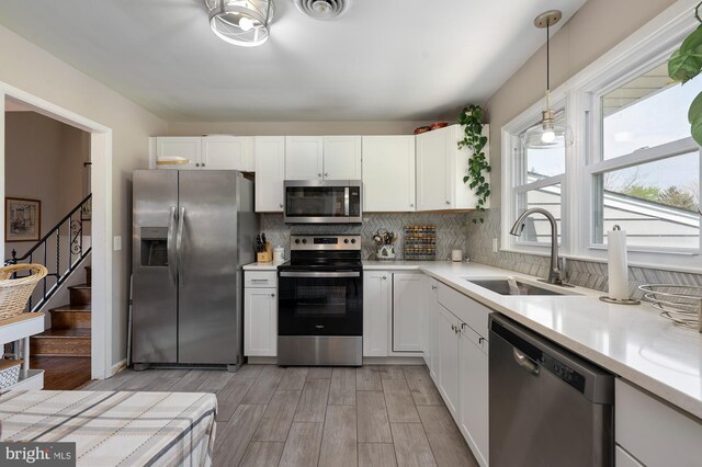 kitchen with visible vents, appliances with stainless steel finishes, a sink, light countertops, and light wood finished floors