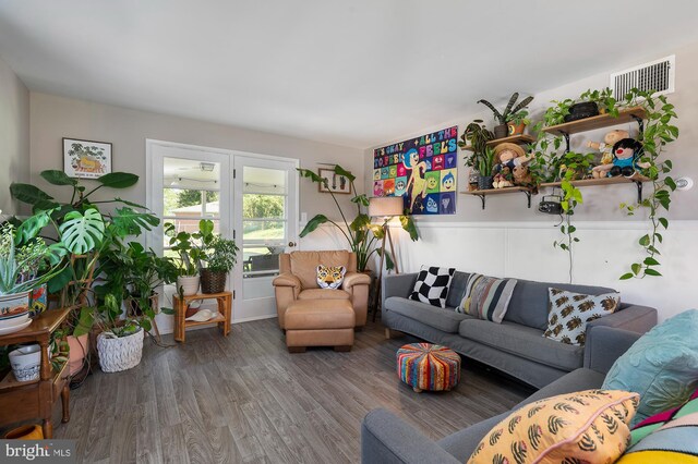 living area with visible vents and wood finished floors