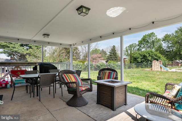 view of patio featuring outdoor dining space, a fenced backyard, a playground, and an outdoor fire pit