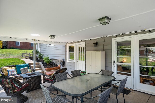 view of patio featuring an outdoor living space with a fire pit, outdoor dining space, and a deck