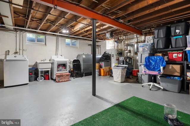 below grade area with a sink, heating fuel, washer and clothes dryer, and a wealth of natural light