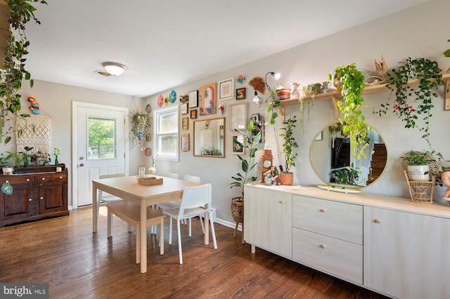 dining space with dark wood-style flooring and baseboards