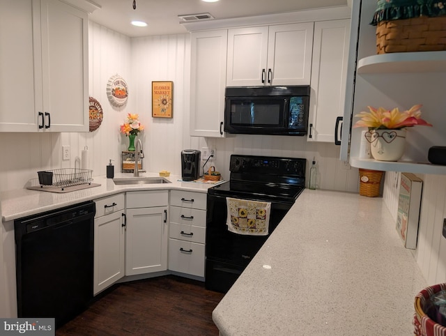 kitchen featuring white cabinetry, visible vents, a sink, and black appliances