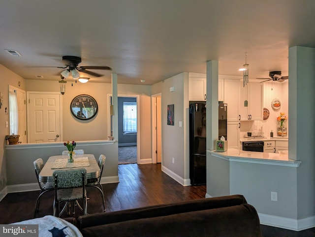 interior space with ceiling fan, visible vents, baseboards, and dark wood-type flooring