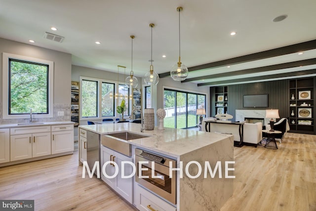 kitchen featuring a sink, recessed lighting, light wood-style flooring, and visible vents