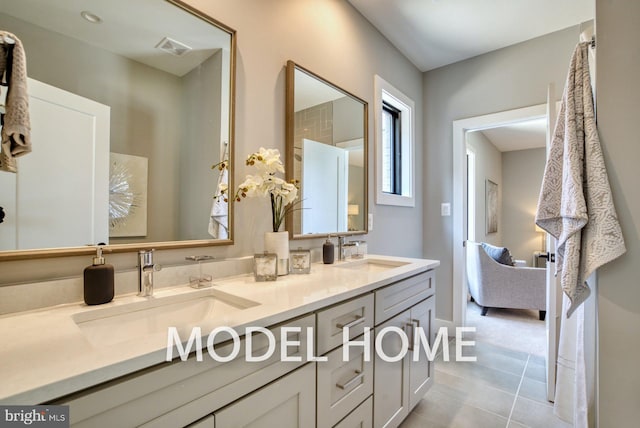 full bathroom with a sink, tile patterned floors, double vanity, and visible vents