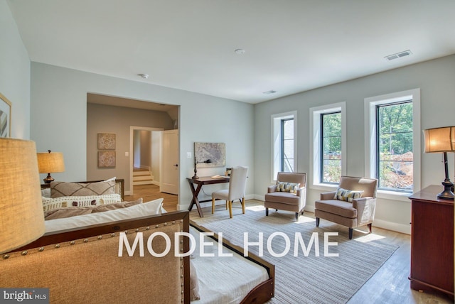 bedroom featuring baseboards, wood finished floors, and visible vents